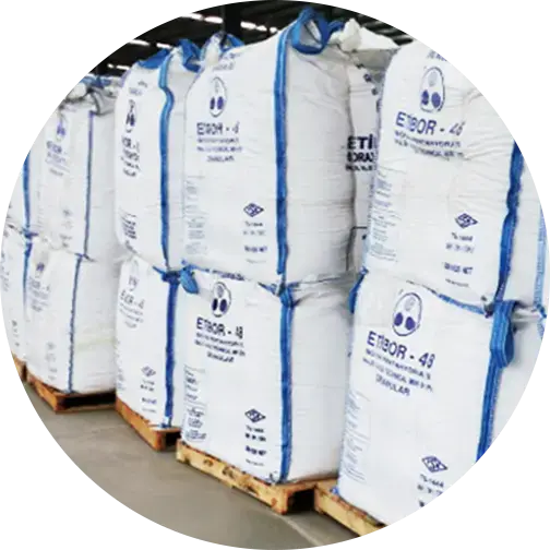 Stacked large white bags labeled ETBOR-48 on wooden pallets in a warehouse setting, suggesting bulk chemical storage.