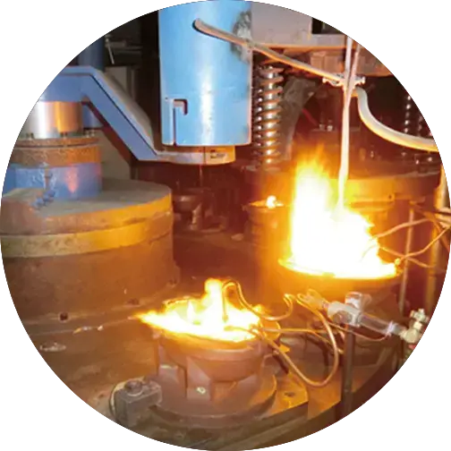 Industrial glass production machinery with blazing flames and automated components in a manufacturing setting.