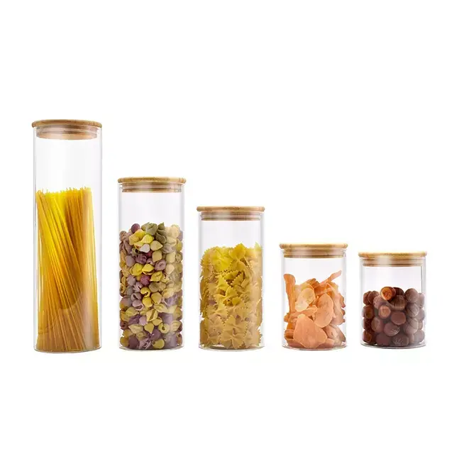 Set of five glass containers with wooden lids holding pasta, dry fruit, and beans, suitable for kitchen storage.