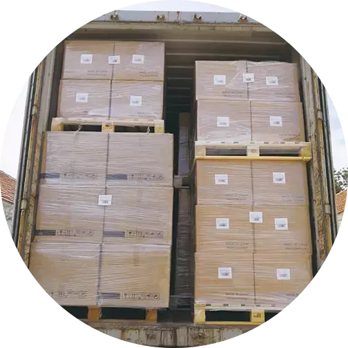 Numerous cardboard boxes wrapped in plastic film stacked tightly inside an open shipping container, ready for transport.