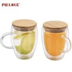 Two double wall glass mugs with bamboo lids, one containing apple slices and the other orange juice, with Pielock branding.