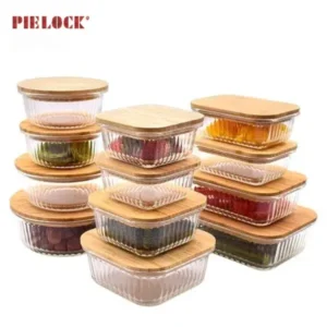 Several stacked glass containers with ribbed sides and bamboo lids, some filled with various foods, highlighting kitchen storage.