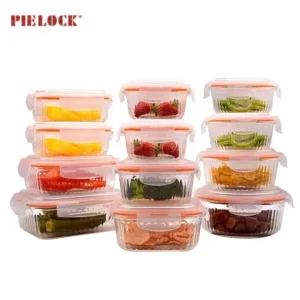 Set of stacked glass food containers filled with various colorful fruits and vegetables, sealed with orange lids.
