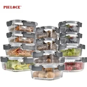 Multiple stacked glass containers with gray lids holding various foods like grapes, salad, and nuts, displayed against a white background.